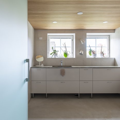 Haasteena remontissa oli tekniikan piilottaminen. Kiintokalustetoimittaja Laitilan Erikoiskaluste Oy onnistui räätälöimään kalusteiden rungot tekniikan tarpeet huomioiden. Lattian pintamateriaaliksi valittiin mikrosementti saumattomuutensa vuoksi. Tasot ovat Corianin Rosemary.