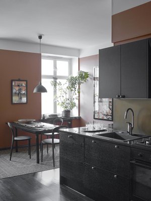 Keittiön seinien  väriksi Marita valitsi terrakotan. Hän on mieltynyt luonnonvärein värjättyihin afgaanimattoihin, joiden rauhalliset värit sopivat kellertäviin suomalaisiin puulattioihin ja ennen kaikkea tämän keittiön mustaksi maalattuun lankkulattiaan.