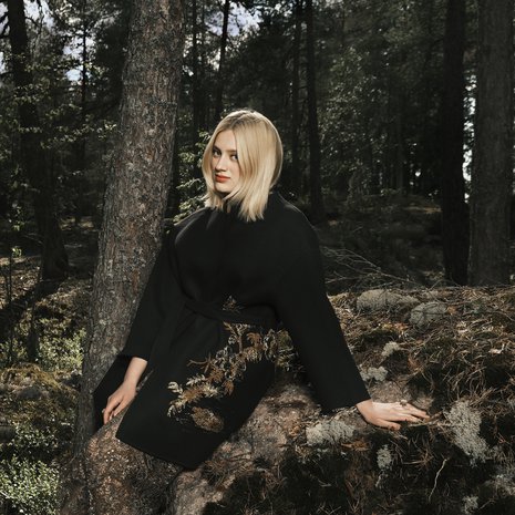 Suomen luonto ottaa ranskalaisen huippumuodin vastaan fantastisesti. Kashmirtakin kultalangoin kirjailtu kuvio sulautuu sammaleeseen luontevasti. Nilkkoihin asti ulottuva, filigraanikuvioitu pitsihame on näyttävä vaate.