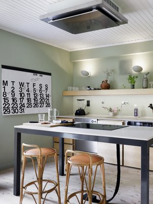 Puuseppä Pekka Koivikko valmisti keittiön mittojen mukaan koivusta. Betonitasot valmisti 16juin.com. Keittiön seinät maalattiin hengittävällä Auro-luomumaalilla. Ruokapöytämäiseen saarekkeeseen upotettiin liesitaso, jonka lattiaan johtavat sähköjohdot sukitettiin siististi pussiin. Liesituuletin sijoitettiin kattoon.