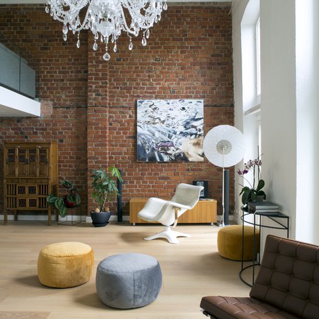 Vanhan kodin valkoinen nahkainen Karuselli -tuoli löysi paikkansa korkean ikkunan edessä. Taideteos on Marcus Eekin. Mooin suuri valkoinen Filigree -lattiavalaisin luo valolla tilaan kauniin filigraanimaisen kuvion.