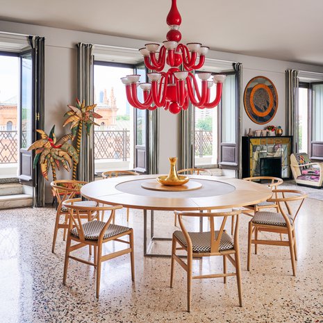 [Kuvateksti] Y-tuolien skandinaavinen tyyli sopii mittatilaustyönä valmistetun pöydän kivi- ja puupintoihin. Punainen katto-kruunu on Murano-lasia. Lattia on Ottavio Missonin suunnittelema.