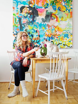 <p><p>Meri-Tuuli leikkii siamilaiskissansa kanssa Roihuvuoren-kodissaan. Taulu seinällä on Ville-Veikko Viikilän teos ’Kevät muuttaa miestä ja heiluva valo ei koskaan nuku’.</p></p>