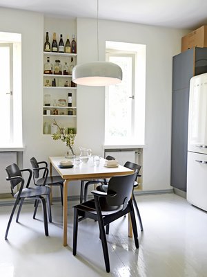 Asunnossa on iso, valkoharmaa keittiö, jossa on paljon säilytystilaa. Flosin Smithfield-valaisin on hankittu Vepsäläiseltä. Suurikokoinen valaisin sopii yhteen Alvar Aallon klassikkopöydän kanssa. Ilmari Tapiovaaran musta Domus-tuoli hankittiin Aerosta ja neljä Aslak-tuolia Aarnes Designista Töölöstä.