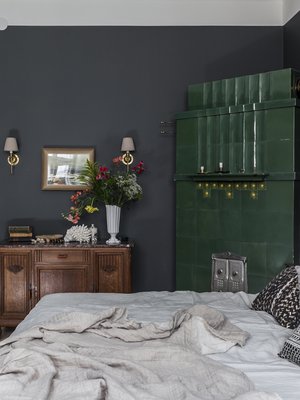 Makuuhuoneen kakluunin syvä vihreä sävy määritti muun huoneen värityksen. Marmorikantinen lipasto löytyi vanhojen tavaroiden liikkeestä. Sängyn tekstiilit luovat mielenkiintoisen pintojen yhdistelmän tummaa taustaa vasten.