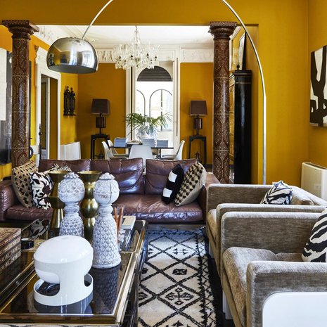 Olohuoneessa Malenen valitsema yllätysväri keltainen tuo upeasti esiin huonekalut ja taiteen. Pitkä sivupöytä on Malenen omasta kotimallistosta vuodelta 2014 ja valaisimet vuoden 2018 kokoelmasta.