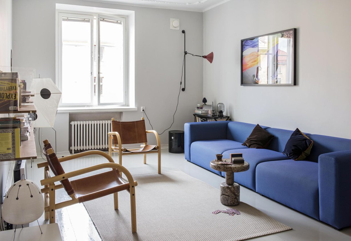 Ben af Shulténin safarituolit pehmentävät modernin olohuoneen väritystä. Muuton sininen Connect-sohva koostuu moduuleista. Juliste on tilattu Fotografiskan museokaupasta. Rock table -marmoripöytä on Tom Dixonin suunnittelema.