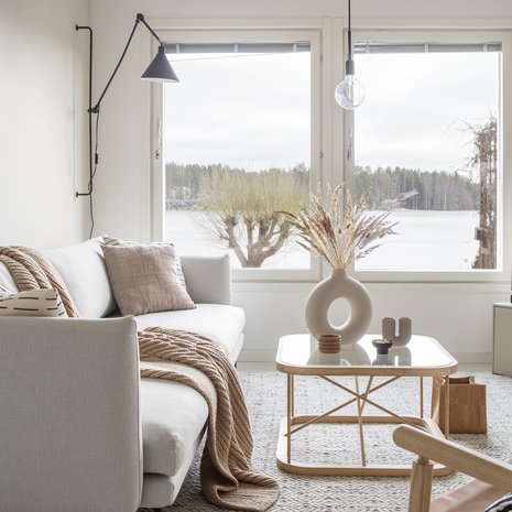 Sohvalta voi ihailla upeaa järvimaisemaa. Linie Designin matto hankittiin Catalinasta, musta seinälamppu on Ellokselta.