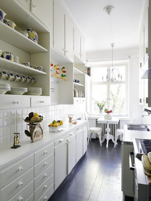 Keittiössä on alkuperäiset kaapistot, joista Ella ei halunnut luopua ergonomiankaan nimissä. Samassa talossa asui aikanaan  astiankuivaus-kaapin keksijä Maiju Gebhard, jonka ansiosta asuntoihin asennettiin tuo aikoinaan ultramoderni keksintö. Keittiön metalliset tuolit ovat Plootusta, pöytä on Rivièra Maisonin. 