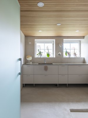 Haasteena remontissa oli tekniikan piilottaminen. Kiintokalustetoimittaja Laitilan Erikoiskaluste Oy onnistui räätälöimään kalusteiden rungot tekniikan tarpeet huomioiden. Lattian pintamateriaaliksi valittiin mikrosementti saumattomuutensa vuoksi. Tasot ovat Corianin Rosemary.