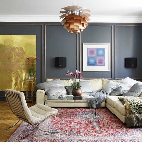 Olohuoneen seinät paneloitiin tummilla puupaneeleilla, joihin maalattiin pronssin-sävyiset koristelistat. Punasävyinen Keshan-matto ja Barcelona-tuoli ovat huutokauppalöytöjä. Lasipöytä on hankittu Vepsäläiseltä. Sohvan päällä on Victor Vasarelyn työ.