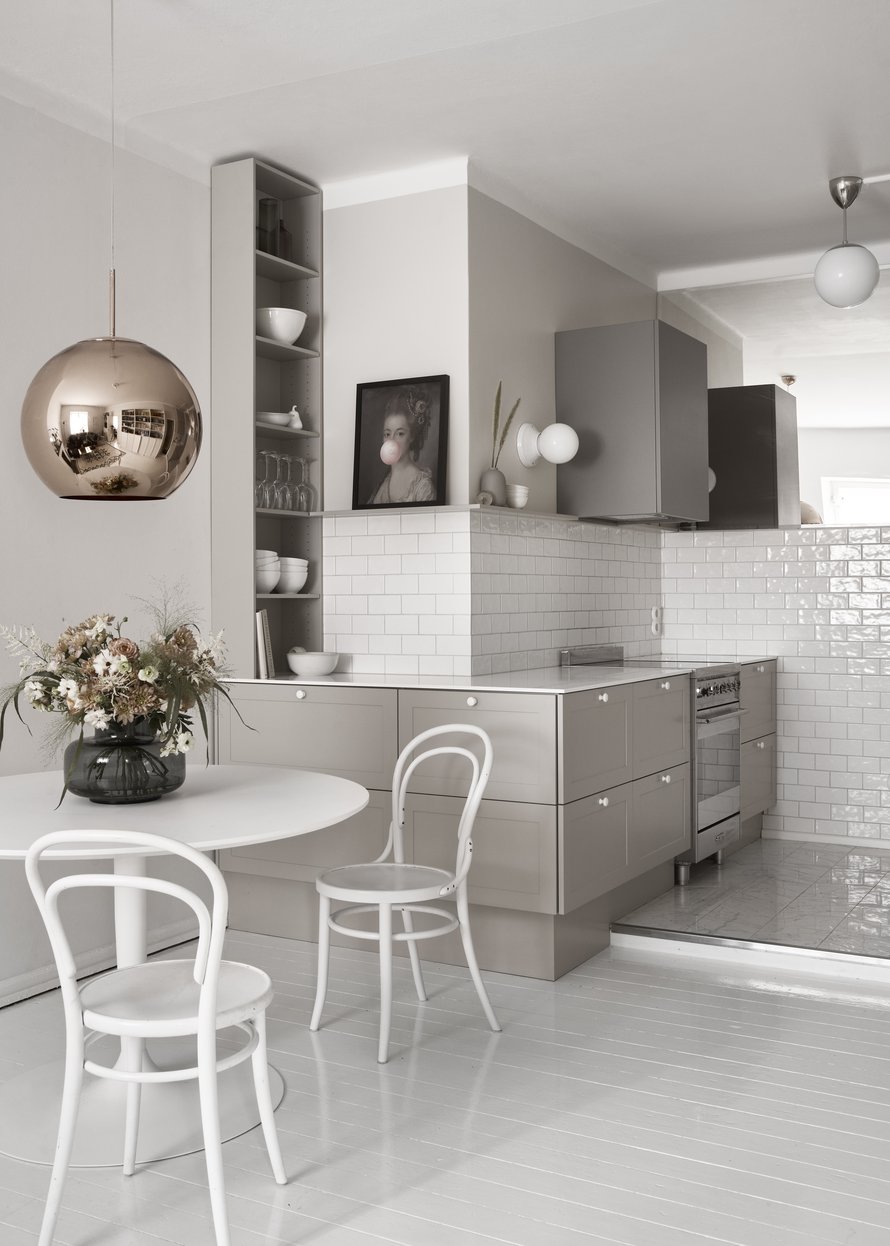 Yläkaapittomuus ja peili tekevät keittiösyvennyksestä keveän. Liesituuletinkaappi on Nixin mallistoa, ja seinävalaisimet ovat Ikean. Kukkakimppu on Johanna Pauliina Designin toteuttama.