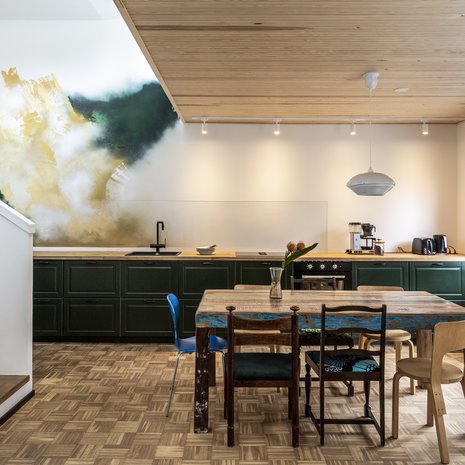 Taiteilija Juha Lahtisen tilateoksen vihreä väri toistuu myös Ikean keittiökaapeissa. Lasilevy suojaa seinää tiskialtaan ja lieden kohdalla. Liesituuletin on integroitu. Kodinkoneet LG ja Ikea. Keittiönpöydän Titi on hankkinut Volcano Designista. Tuoleista osa on Ossin perimiä.
