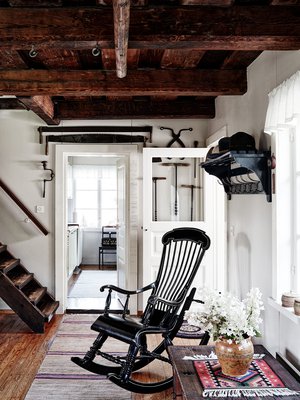 Talon keinutuolit ovat perheen aarteita vanhempien lapsuudesta. Tuvan portaikko johtaa yläkertaan ja ovi keittiöön. Päätalon keittiö on remontoitu 2000-luvulla.