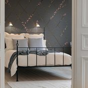 Winding Spring -tapetilla (36 e / m2) kasvaa kukkaan puhkeamaisillaan oleva hempeä oksaruudukko. Kuva: <span class="photographer"><a href="http://rebelwalls.fi" target="_blank">Rebel Walls</a></span>