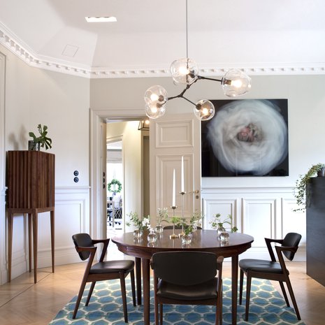 Asunnon suuresta  salongista sisustusarkkitehti Olle Rex suunnitteli keittiön ja ruokailutilan. 1950-luvun pöytä ja tuolit ovat tanskalaisen  Kai Kristensenin suunnittelemat ja kattovalaisin amerikkalaisen Lindsey Adelmanin käsialaa. Sinivihreäkuvioinen matto on Rug Companystä.