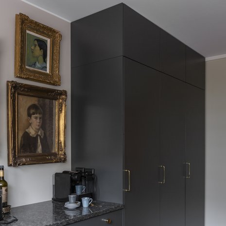 Kultakehyksiset muotokuvat ja perintömaalaukset tuntuivat muualla asunnossa liian raskailta, mutta ne löysivät paikkansa keittiön työtason päältä. Integroidut täyskorkeat kylmälaitteet ovat Electroluxin mallistosta