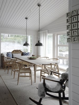 Ruokailutila on aivan keittiön kyljessä. Sisustuksen helmet ovat Hans J. Wegnerin ruokapöytä ja CH24-tuolit. Niiden kevyt rakenne ja kaunis muotoilu sopivat yhteen Matin perintökeinutuolin ja Fiskarsin antiikkimarkkinoilta ostetun talonpoikaissohvan kanssa.