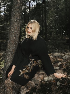 Suomen luonto ottaa ranskalaisen huippumuodin vastaan fantastisesti. Kashmirtakin kultalangoin kirjailtu kuvio sulautuu sammaleeseen luontevasti. Nilkkoihin asti ulottuva, filigraanikuvioitu pitsihame on näyttävä vaate.