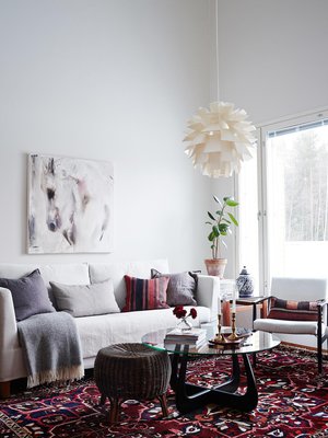 Olohuoneen matto  on Carpetvistasta ja Elinan mielestä täydellinen tyydyttämään värinhimoa. HT-Collectionin sohvan ja sohvapöydän Elina  hankki nettihuutokaupasta. Sohvan yllä  on Katja Hannulan Heijastuksia-teos.