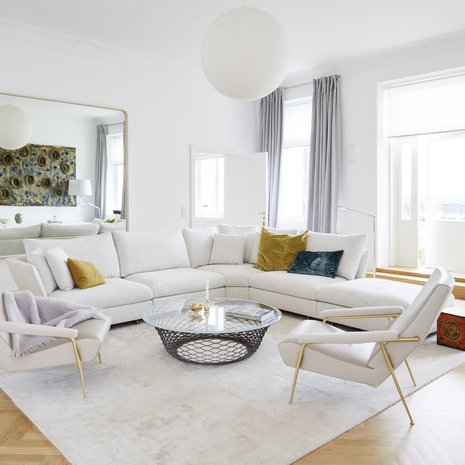 Lähes neljä metriä korkea, valoisa olohuone avartui remontissa, kun seinät maalattiin Tikkurilan Lumi-maalilla ja katto himmeän valkoisella Siro-maalilla. Holiday-sohva ja Teso-päytä ovat Moltenin. Sirot, nahkaiset nojatuolit on suunnitellut Gio Ponti. Peilin kautta heijastuu porvoolaisen taiteilijan Harri Leppäsen veistoksellinen maalaus.