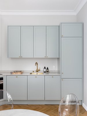 Vaaleanvihreä keittiö toimii kauniisti yhteen lämpimän harmaiden seinien ja klassisen kalanruotoparketin kanssa. Keittiön sävy on Tikkurilan Symphony K495.