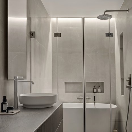 Kauniit pintamateriaalit ja harkittu valaistus luovat tilan, jossa on hyvä olla.Riittävän pieni amme löytyi Laattapisteen valikoimista, samoin kauniit hiekkakiveä muistuttavat laatat. Pienet syvennykset seinäpinnoissa lisäävät jonkin verran kuluja, mutta tuovat paljon käyttömukavuutta.