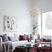 Olohuoneen matto on Carpetvistasta ja Elinan mielestä täydellinen tyydyttämään värinhimoa. HT-Collectionin sohvan ja sohvapöydän Elina hankki nettihuutokaupasta. Sohvan yllä on Katja Hannulan Heijastuksia-teos.