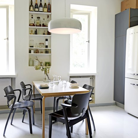 Asunnossa on iso, valkoharmaa keittiö, jossa on paljon säilytystilaa. Flosin Smithfield-valaisin on hankittu Vepsäläiseltä. Suurikokoinen valaisin sopii yhteen Alvar Aallon klassikkopöydän kanssa. Ilmari Tapiovaaran musta Domus-tuoli hankittiin Aerosta ja neljä Aslak-tuolia Aarnes Designista Töölöstä.