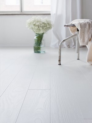 Valkoinen lattia raikastaa hirsimökin ilmeen, Timberwisen Polar-saarniparketti 88,70 e/m², Netrauta.fi.