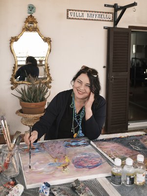 Nanna Susi Rooman-kotinsa terassilla. Koti on nimetty hänen poikansa Raffaellon mukaan Villa Raffaelloksi. Musta teline ovenpielessä on pojan nyrkkeilysäkkiä varten. Seinäpeilistä heijastuu Nannan mukaan koko Rooma. "Myös maalaaminen on pitkälle katsomista."