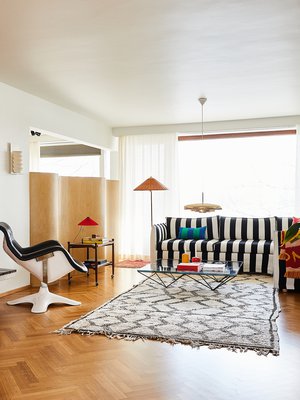 Pitkänmallisen olohuoneen toisella seinällä on alkuperäinen punatiilitakka. Yrjö Kukkapuron Karuselli-tuoli ja rahi tulivat Ekan aiemmasta kodista. Seinämän takana on vierashuone. Kulmasohva on Hakolan Filippa ja sohvapöytä Annaleenan edelliseen kotiinsa hankkima B&B Italian Alanda, jonka on suunnitellut Paolo Piva. Jalkavalaisin on Gubin.