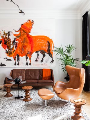 Olohuoneen sisustus on tehty Marjatta Tapiolan Kaksipäinen Härkä -teoksen ehdoilla. Børge Møgensenin nahkainen vintagekalusto on peräisin nettikauppa Nord3.ch:sta. Charles ja Ray Eamesin suunnittelemat puujakkarat ovat laskutasoja ja lisäistuimia. Huopapaloista tehty matto on Lignet Roset´n. Serge Mouillen suunnittelema kattovalaisin on Nord3.ch:sta. Keskellä on Eero Saarisen pieni Tulppaani-pöytä.