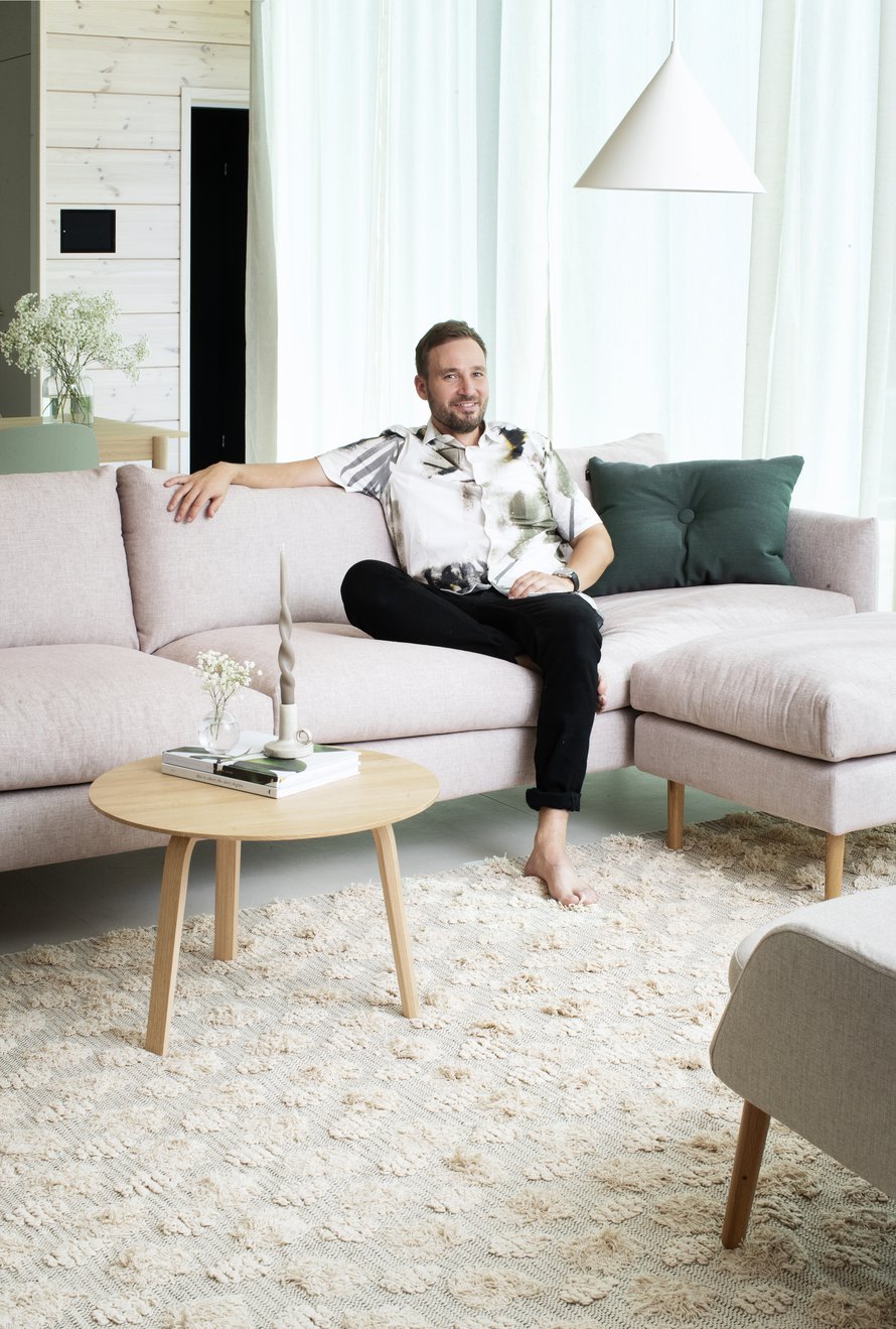Juuso ja hänen puolisonsa halusivat lapsiperheen kotiin väriä. Vaaleanpunaisen ja vihreän eri sävyt toistuvat kodin yksityiskohdissa. Olohuoneen sohva Kuusilinna, matto Anno Collection.