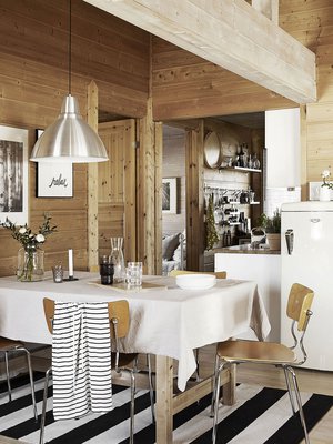 Tällä mökillä lattia on hiottu ja lakattu kuultovalkoisella, samoin kattopalkit. Seinien hirret on jätetty puunvärisiksi.