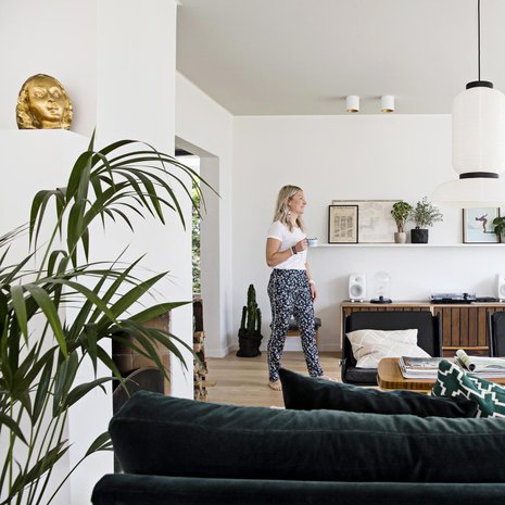 Olohuoneeseen ei haluttu televisiota vaan siellä seurustellaan ystävien kanssa, ihaillaan merimaisemaa tai takkatulta. Lämpöä avaraan tilaan tuo harmaaksi maalattu katto. MeliMelin samettisohva hankittiin Zarrosta.  Formakamin JH 3 -valaisin on Armaksesta. Takaseinän vintagelipasto löytyi pihakirppikseltä Raumalta.  Esko Pajamiehen suunnittelemat Merivaaran Bonzo-nojatuloit ovat isovanhempien vanhat.