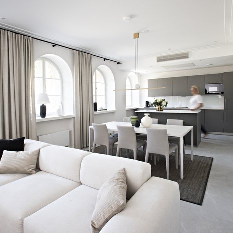 Harmaa keittiö määritteli pitkälti asunnon väritystä. Vaaleaa värimaailmaa on sävytetty pienillä mustilla mausteilla ympäri asuntoa. Ruokapöytä ja tuolit ovat Skannosta, valaisin pöydän yllä on Luceplanin.