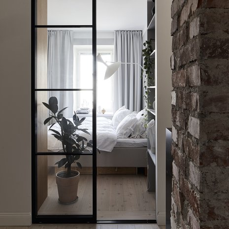 Makuuhuoneen lasiovet teetetttiin Suomen Lasitehtaassa. Kitinvärisellä kankaalla verhoiltu vuode Familon. Valaisin on Le Corbusierin suunnittelema Lampe de Marseille.