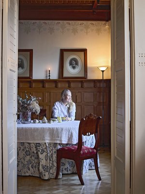  Ruokasalin kalusteet ovat perittyjä ja huutokaupoista hankittuja. Seinillä on vanhoista pikku valokuvista digitoituja sukupotretteja. "Tällaiseen pönötysruokasaliin piti saada pönöttäviä tyyppejä."