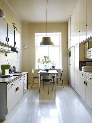 Keittiö on yhä alkuperäisessä asussaan. Seinät, katto ja lattia maalattiin kaikki samalla kellertävällä sävyllä kuin kaapit, jotta tunnelmasta tuli harmoninen ja mittasuhteet hämärtyvät. Ainoat uudet hankinnat asuntoon ovat Ateljé Lyktanin Bumling-riippuvalaisin sekä Ikean mustat pikkutuolit.