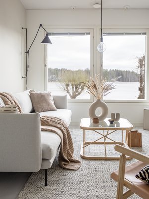Sohvalta voi ihailla upeaa järvimaisemaa. Linie Designin matto hankittiin Catalinasta, musta seinälamppu on Ellokselta.
