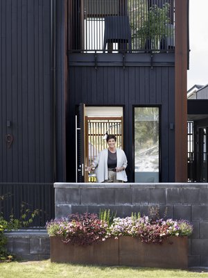 Kadunpuoleisen sisäänkäynnin tunnelma ja laatikkoistutukset elävät vuodenaikojen mukaan.