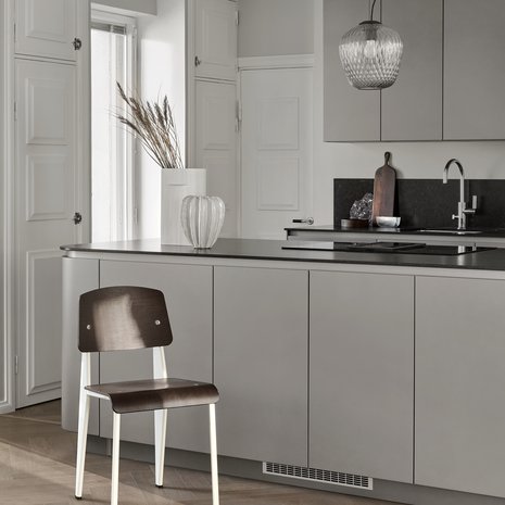 Saarekkeen päälle valittiin modernilla tavalla vanhaa henkivät kattovalaisimet, malli on &Traditionin Blown harmaalla lasilla. Vaalea korkea maljakko on Muuton Ridge.