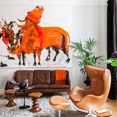 Olohuoneen sisustus on tehty Marjatta Tapiolan Kaksipäinen Härkä -teoksen ehdoilla. Børge Møgensenin nahkainen vintagekalusto on peräisin nettikauppa Nord3.ch:sta. Charles ja Ray Eamesin suunnittelemat puujakkarat ovat laskutasoja ja lisäistuimia. Huopapaloista tehty matto on Lignet Roset´n. Serge Mouillen suunnittelema kattovalaisin on Nord3.ch:sta. Keskellä on Eero Saarisen pieni Tulppaani-pöytä.